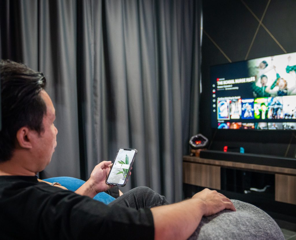 Daniel operating the smart TV in his home at Punggol Northshore