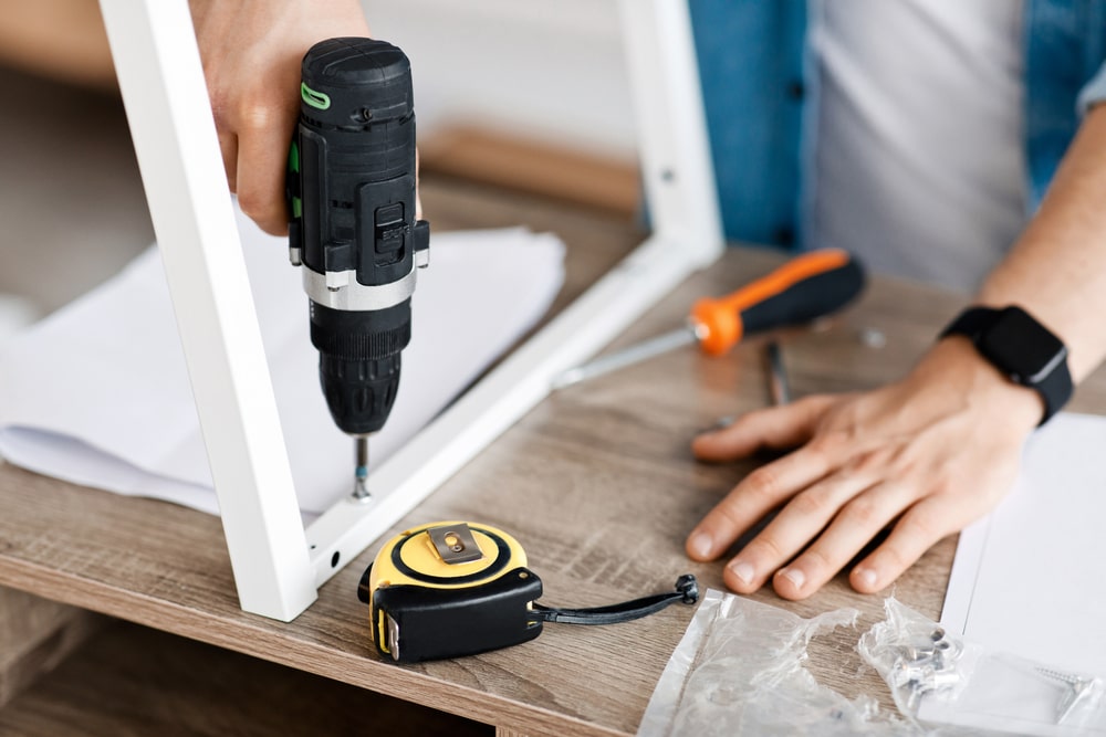 Photo of a man holding a power drill